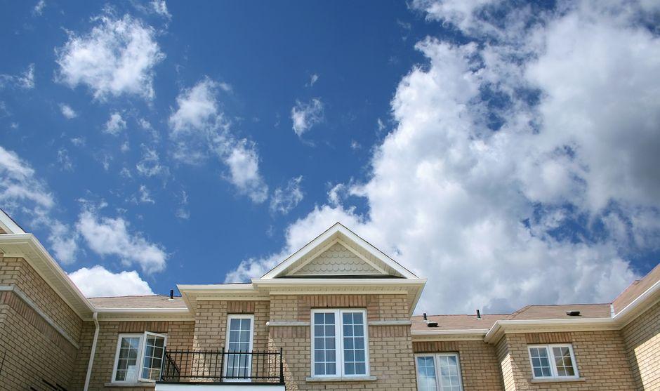 Brown Bricked House under Cloudy Skies